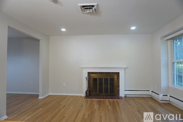 A living room with a fireplace and wooden floors.