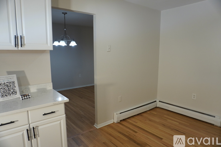 A kitchen with white cabinets and a QR code on the counter.