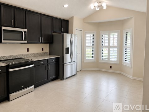 A kitchen with black cabinets and stainless steel appliances.