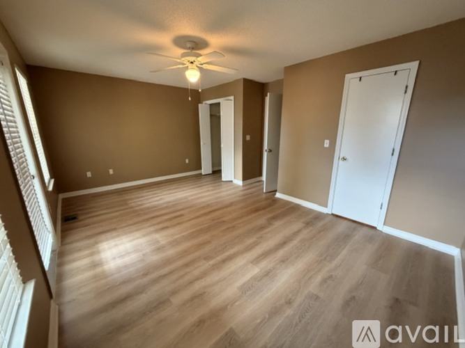 A room with wooden flooring and a ceiling fan.