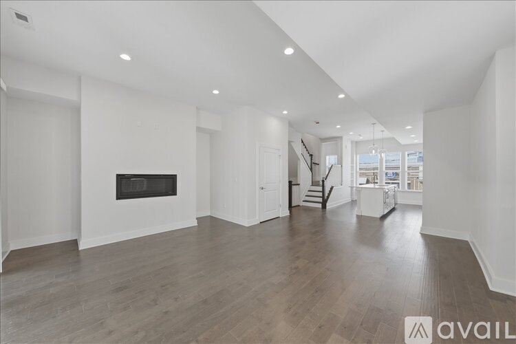 A spacious living room with a fireplace and wooden flooring.
