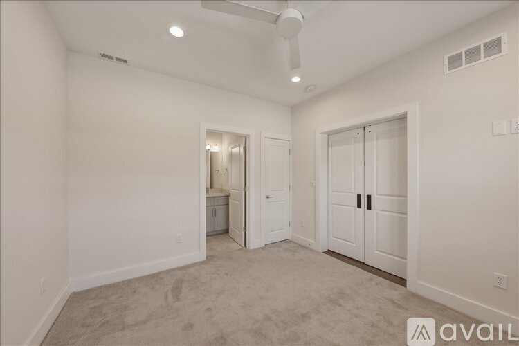A spacious room with a fan and a carpeted floor.