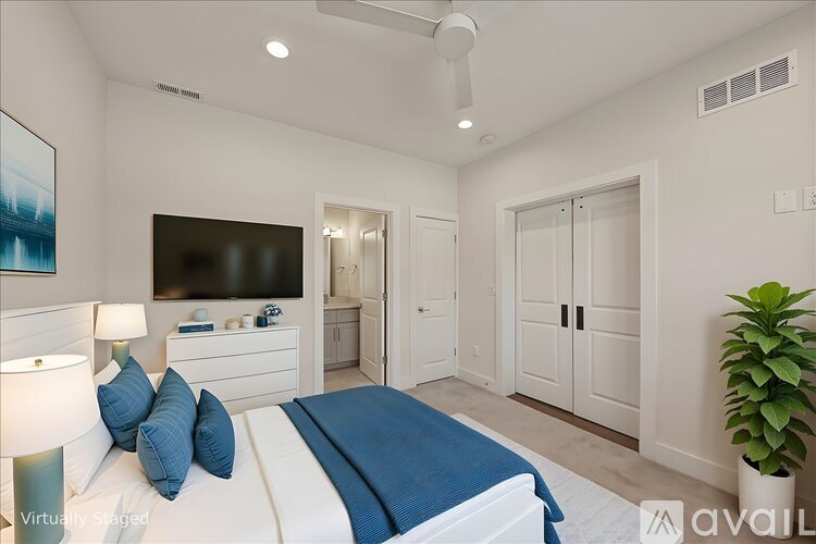 A bedroom with a bed, a television, and a plant.