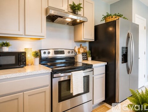 A modern kitchen with a black refrigerator and stainless steel appliances.