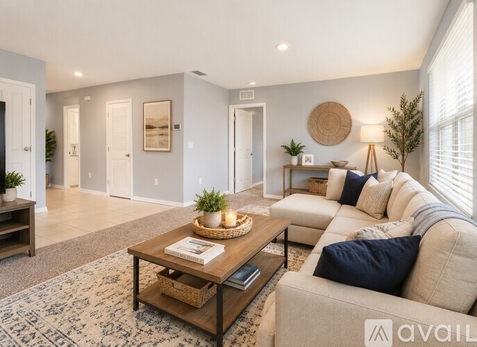A living room with a beige couch, a coffee table, and a rug.