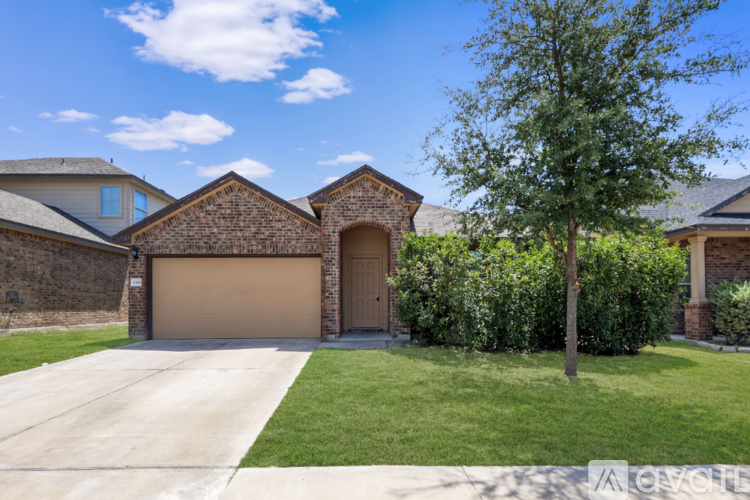 A house with a brown garage door and a tree in front.