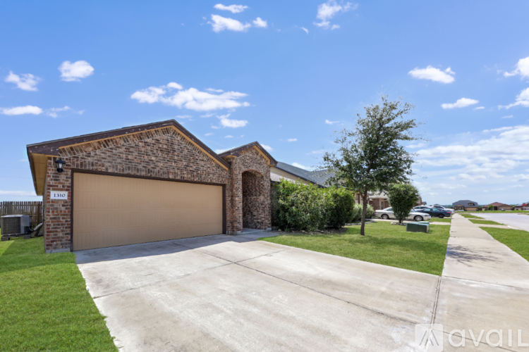 A house with a garage and a driveway in front of it.