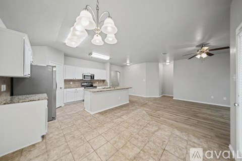 A kitchen with white cabinets and a tile floor.
