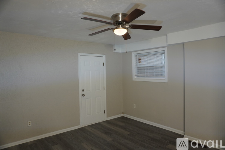A room with a ceiling fan and a window with blinds.