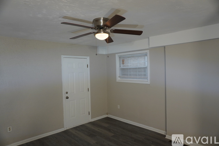 A room with a ceiling fan and a window with blinds.