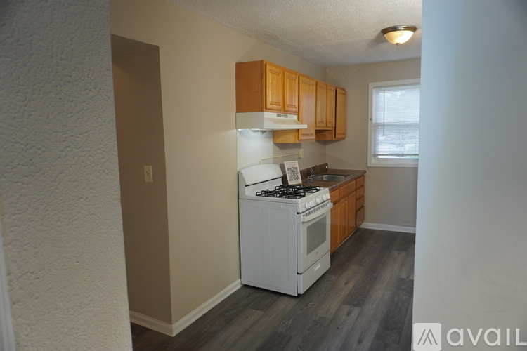 A kitchen with a white stove and wooden cabinets.