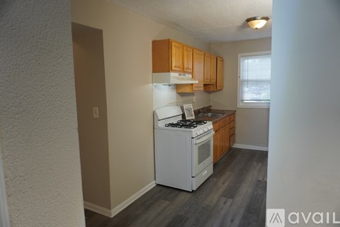 A kitchen with a white stove and wooden cabinets.