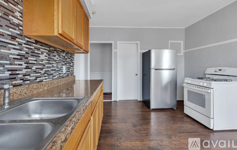 A kitchen with a stainless steel refrigerator and a white oven.