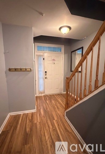 A hallway with wooden floors and a white door.