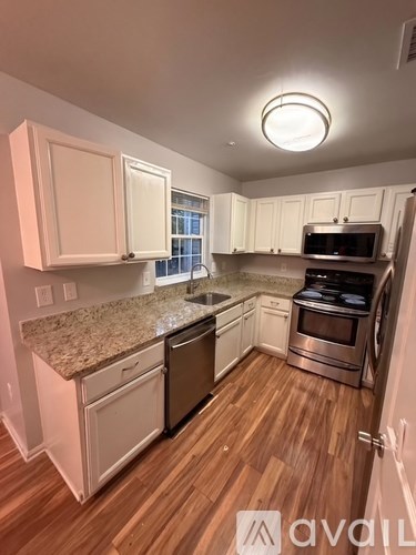 A kitchen with white cabinets and a granite countertop.