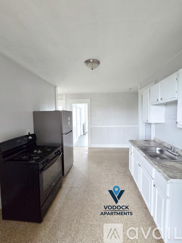 A kitchen with a black stove top oven and white cabinets.