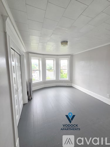 A room with a Vodock Apartments logo on the floor.