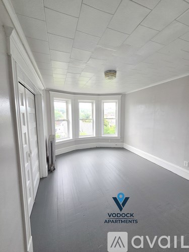A room with a Vodock Apartments logo on the floor.