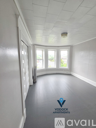 A room with a logo of Vodock Apartments and Avail on the floor.