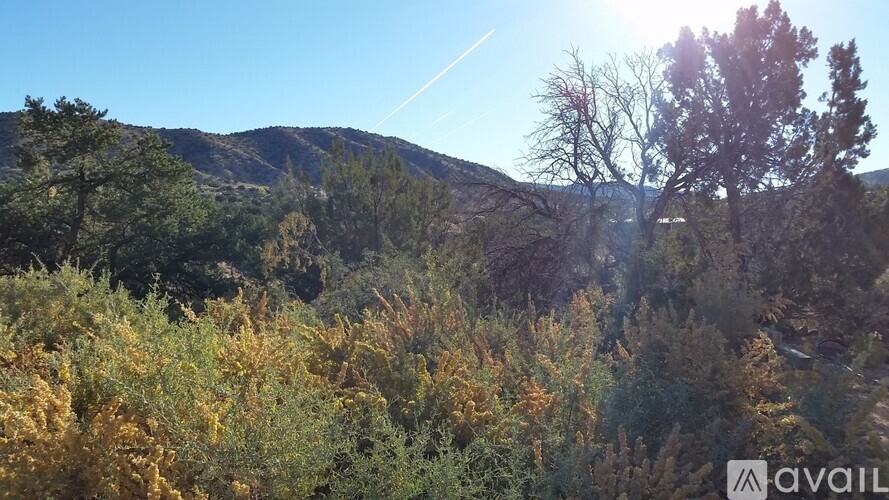 A mountainous landscape with trees and a clear sky.