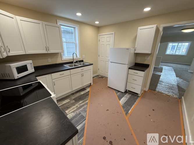 A kitchen with black countertops and white cabinets is available for rent.