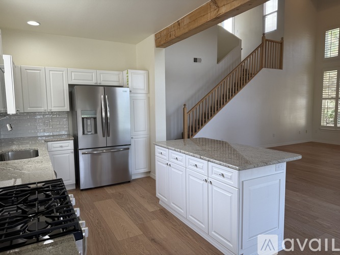 A kitchen with a stove top oven and a refrigerator.