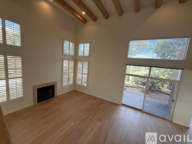 A spacious room with wooden floors and a fireplace is available for rent.
