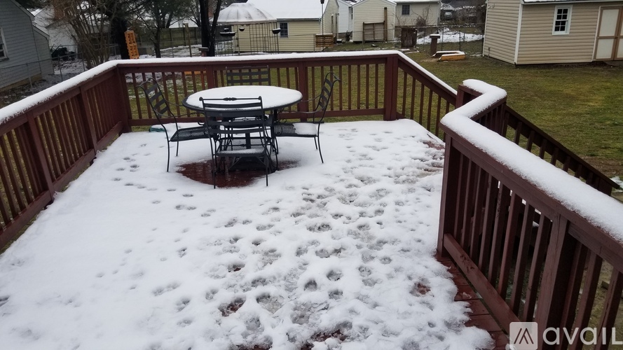 A patio with a table and chairs covered in snow.