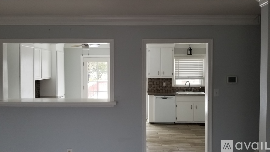 A kitchen with white cabinets and a window.