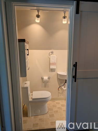 A white toilet is in a small bathroom.