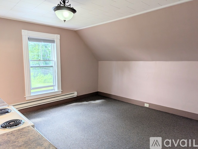 A room with a window and a wall-mounted light fixture.