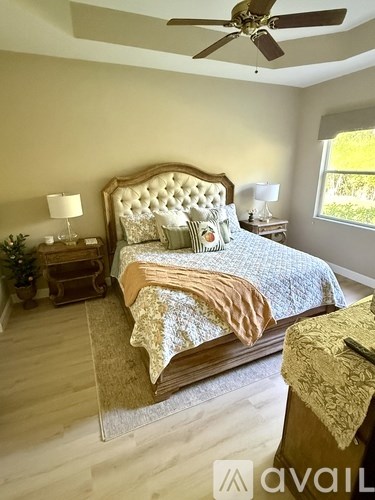 A bedroom with a large bed and a ceiling fan.