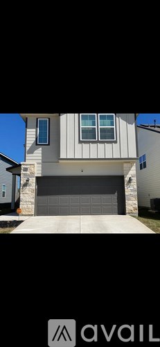 A modern house with a large garage door.