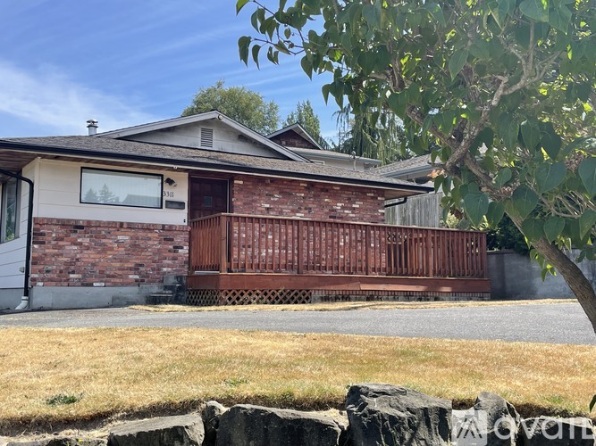 A house with a brown brick exterior and a wooden fence.