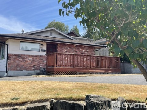 A house with a brown brick exterior and a wooden fence.