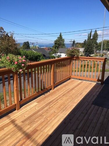 A wooden deck with a railing and flowers on it.