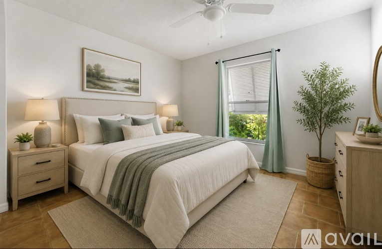 A well-lit bedroom with a large bed and a painting on the wall.