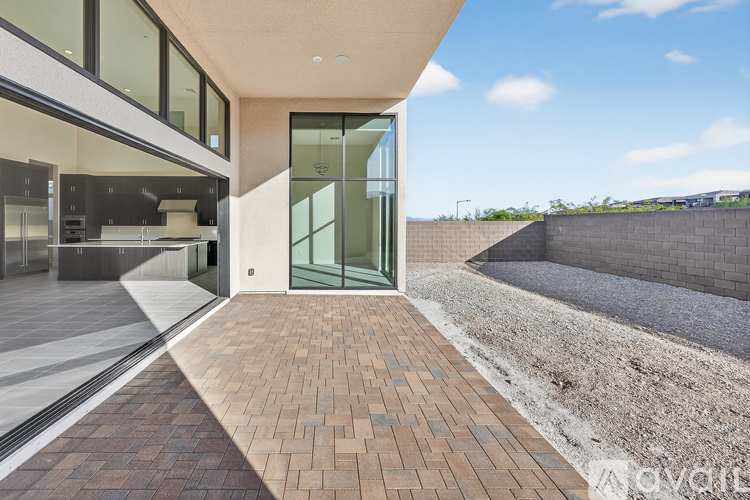 A modern house with a glass door entrance and a brick walkway leading to it.