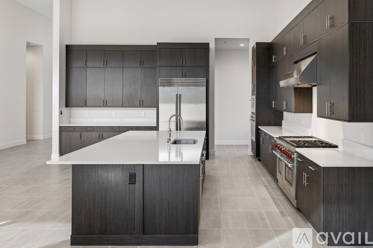 A modern kitchen with dark wood cabinets and a white island.