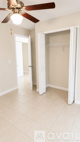 A room with a ceiling fan and a white door.