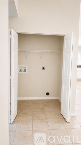 A small, empty room with a doorway leading to another room.