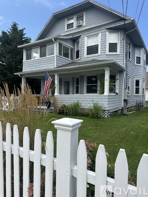 A house with a white picket fence in front.