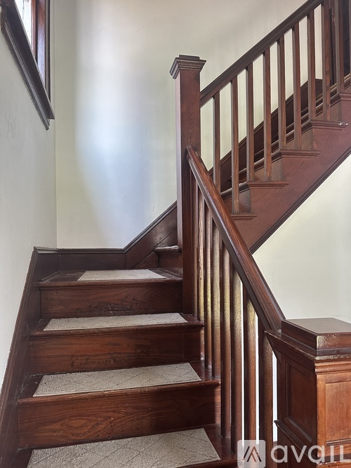 A wooden staircase with a carpeted stair runner.
