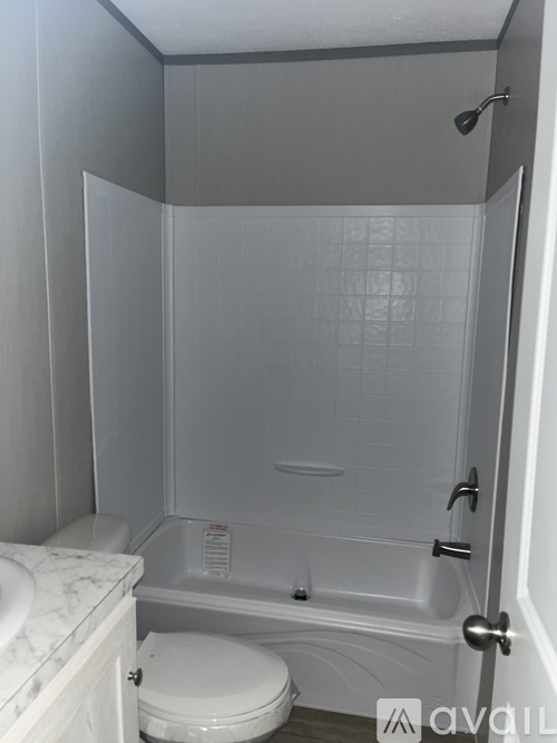 A white toilet sits next to a walk-in shower.