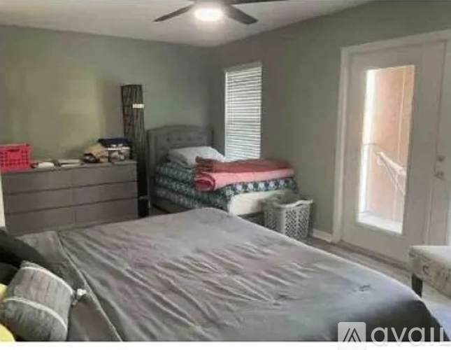 A bedroom with a large bed and a window.