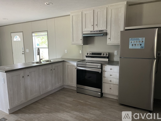 A kitchen with a refrigerator, oven, and cabinets.