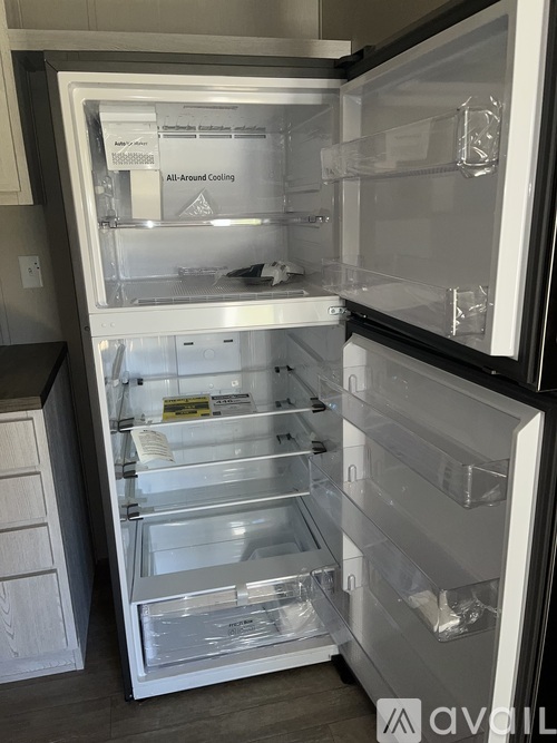 A white refrigerator with the door open and shelves inside.