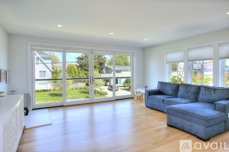 A living room with a grey couch and a white cabinet.