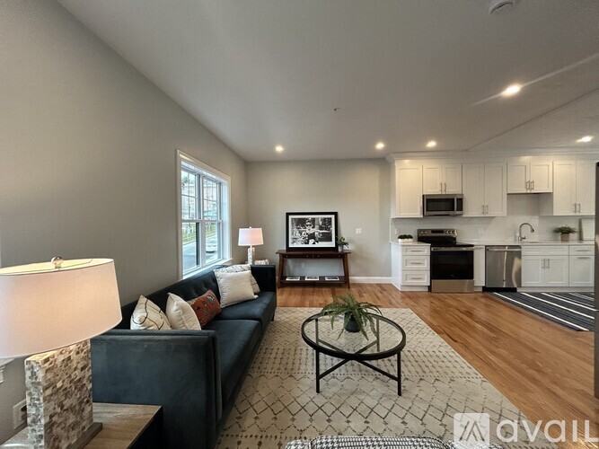 A living room with a couch, coffee table, and a television.