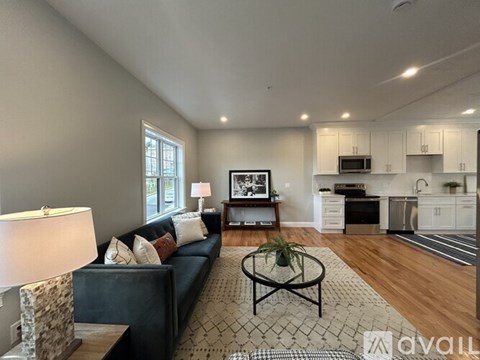 A living room with a couch, coffee table, and a television.